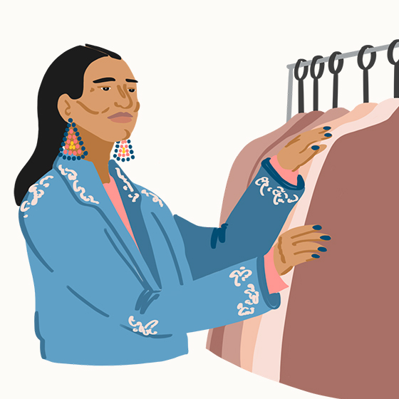 Person with beaded earrings looking a clothing on a rack