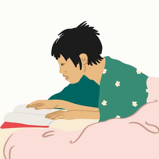 Young person reading a book in bed
