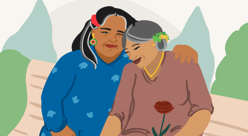 Two people sit on a park bench. Both are smiling peacefully, one's arm around the other's shoulder.